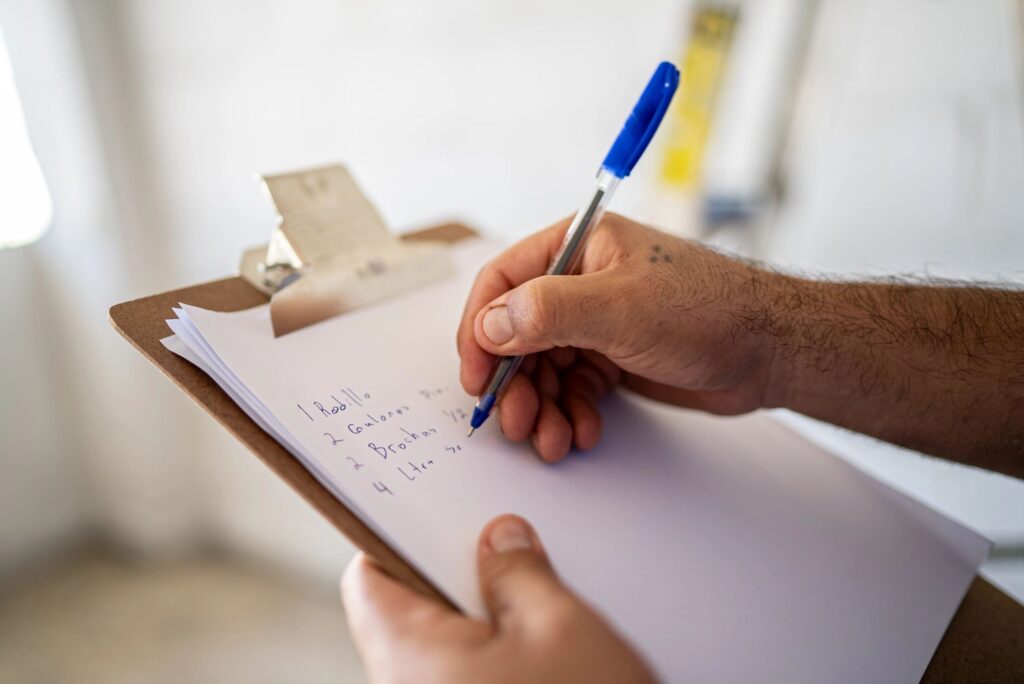 Close-up of man writing on clipboard at construction site